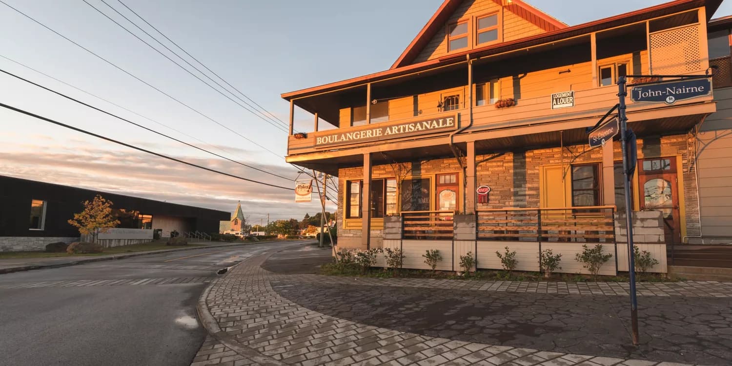 Storefront of the Pains d'Exclamation bakery in La Malbaie at dawn