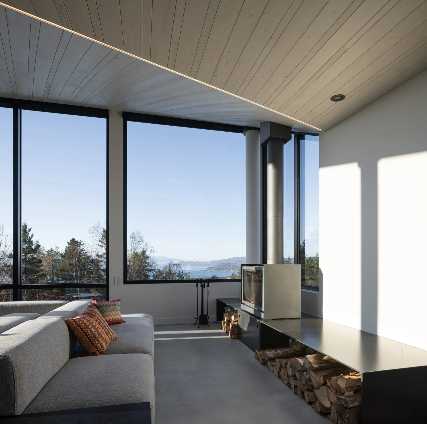 Living room with fireplace and river view at the L'Embâcle chalet