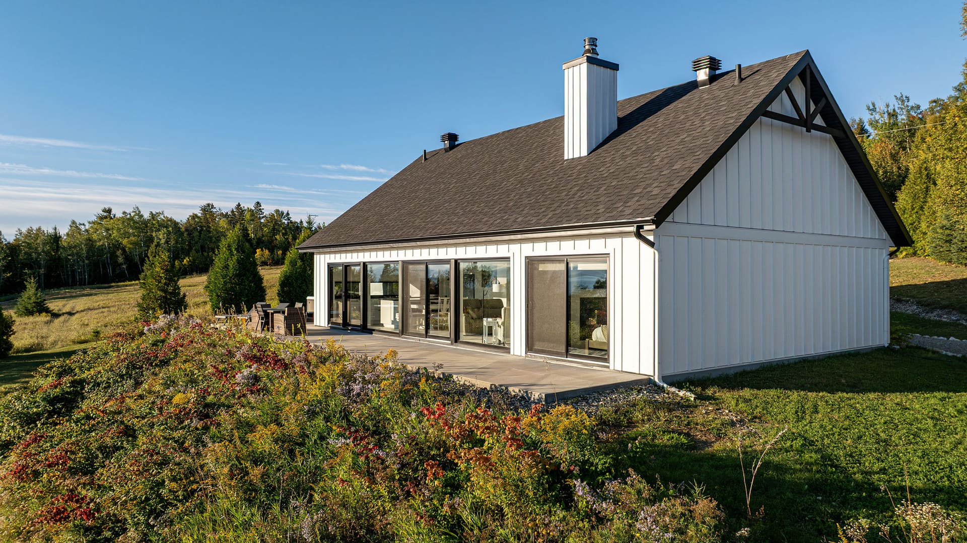 Arrière de la maison et son mur de baies vitrées ouvert sur le fleuve, Saint-Irénée, Charlevoix