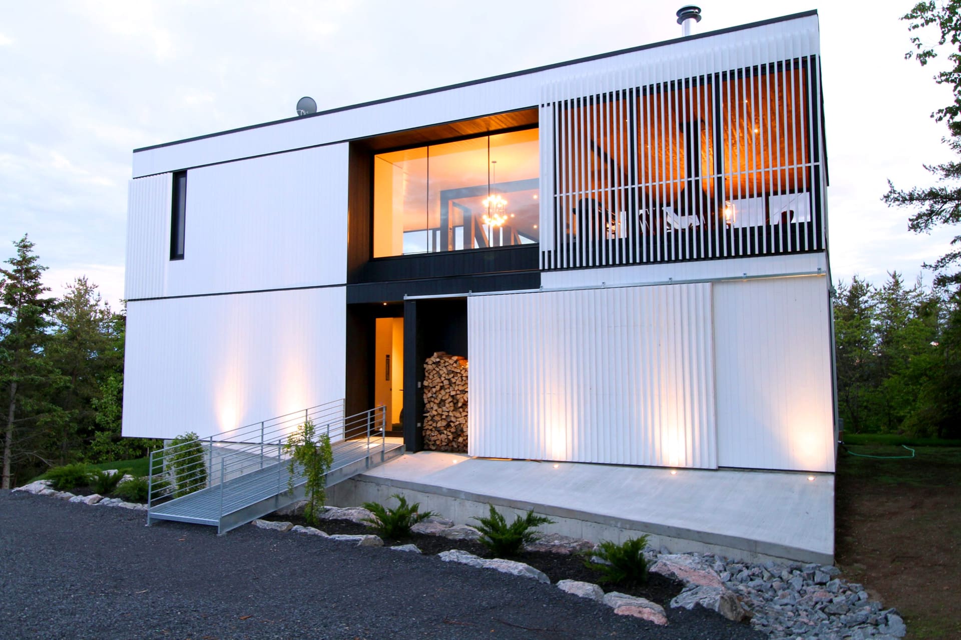 Villa La Blanche au crépuscule, façade vitrée illuminée, Charlevoix
